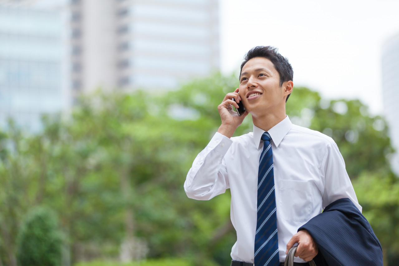 ヘルメットを持ちながら空を見上げてるスタッフ